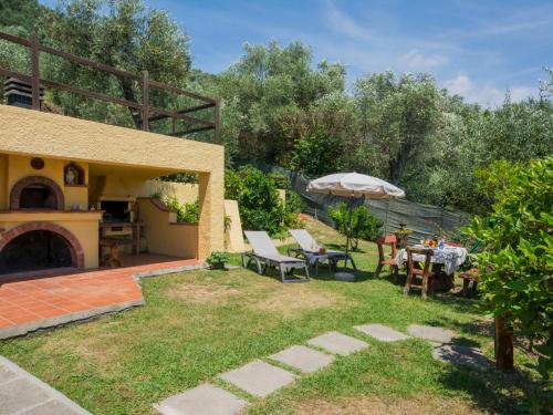 a garden with a table and chairs and an umbrella at Holiday Home Le Bozzelle by Interhome in Corsanico-Bargecchia