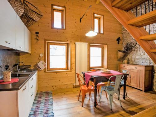 a kitchen and dining room with a table and chairs at Apartment Albergo Diffuso - Cjasa Ustin-3 by Interhome in Barcis