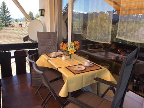 Apartment Panorama by Interhome في Berghofen: طاولة مع قطعة قماش صفراء وكراسي على شرفة