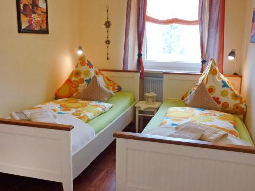 twee bedden in een kleine kamer met een raam bij Apartment Panorama by Interhome in Berghofen