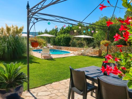 a backyard with a table and a swimming pool at Apartment Chantal-4 by Interhome in Rabac