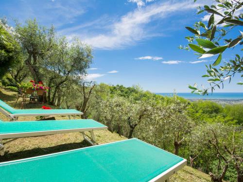 two picnic tables on a hill with the ocean in the background at Holiday Home Casaccia by Interhome in Mommio