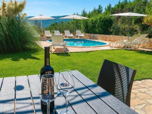 a bottle of wine sitting on a table with wine glasses at Apartment Chantal-4 by Interhome in Rabac