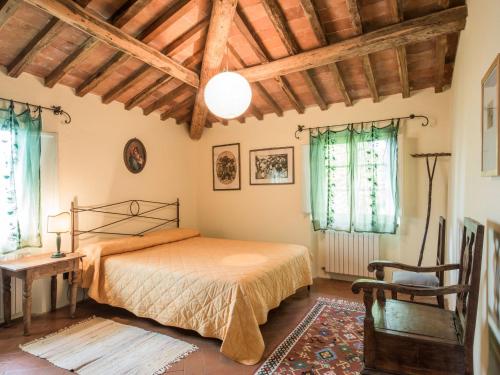 a bedroom with a bed and a chair and windows at Holiday Home Casaccia by Interhome in Piano di Mommio