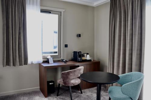 a room with a desk and two chairs and a table at Best Western Plus Le Fairway Hotel & Spa Golf d'Arras in Anzin-Saint-Aubin
