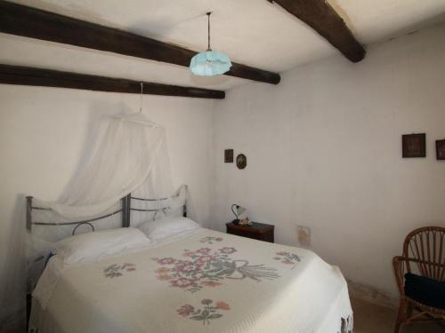 チェーリエ・メッサーピカにあるHoliday Home Trullo Selva by Interhomeのベッドルーム1室(花柄のベッドカバー付きの白いベッド1台付)