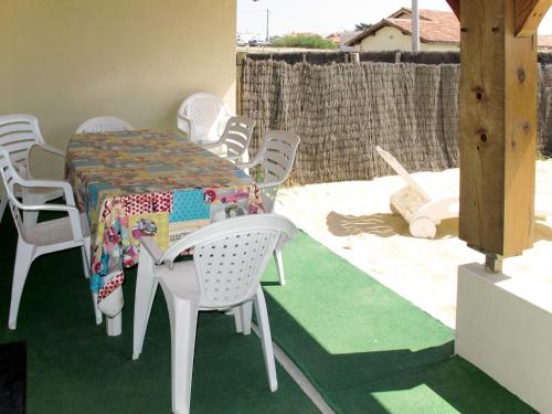 a table with white chairs and a table with a table cloth at Holiday Home La Chapelle - CON100 by Interhome in Contis-les-Bains