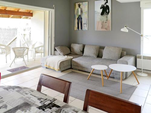 a living room with a couch and a table at Holiday Home La Chapelle - CON100 by Interhome in Contis-les-Bains