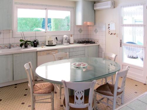 une cuisine avec une table et des chaises en verre dans l'établissement Holiday Home Peydecoum by Interhome, à Saint-Geours-de-Maremne
