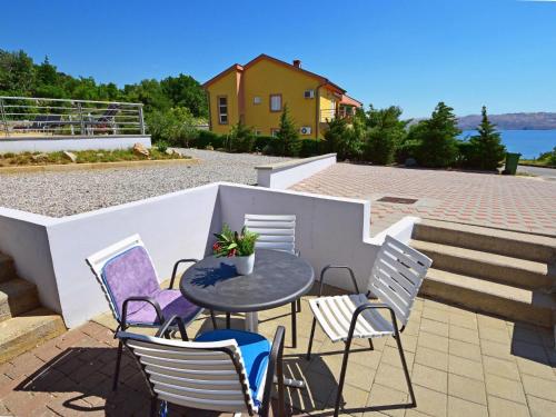 a patio with a table and chairs and a house at Apartment Sani-1 by Interhome in Ribarica
