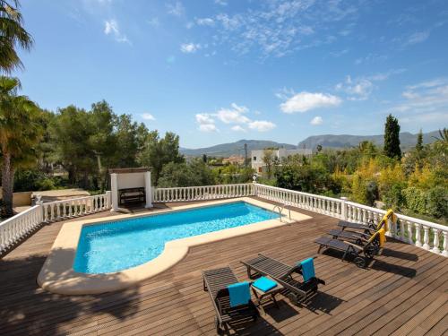 a swimming pool on a wooden deck with chairs and a swimming poolvisor at Holiday Home Osa Menor by Interhome in Montgo