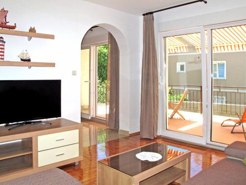 a living room with a flat screen tv and a large window at Apartment Luka - NOV103 by Interhome in Novi Vinodolski