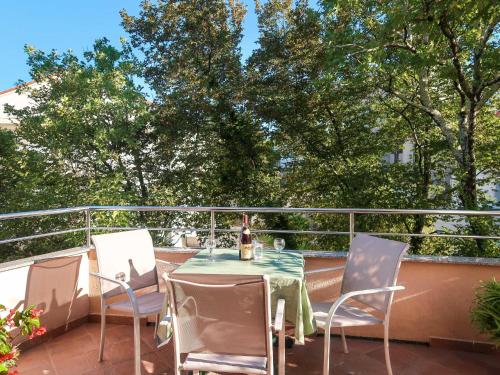 a table and chairs on a balcony with trees at Apartment Vera - MLK326 by Interhome in Malinska