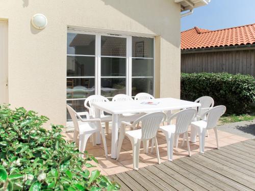 a white table and chairs on a patio at Holiday Home Résidence Dune Blanche - Soleil - BPL320 by Interhome in Biscarrosse-Plage