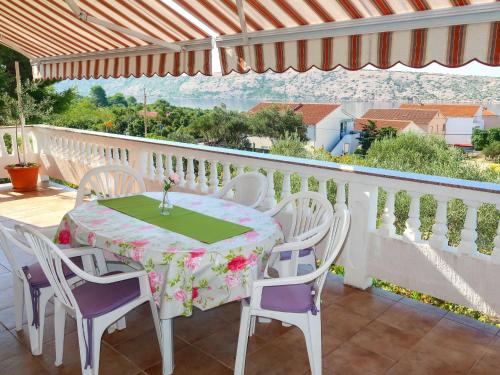 a table and chairs on a balcony with a view at Apartment Matius - RAB105 by Interhome in Rab