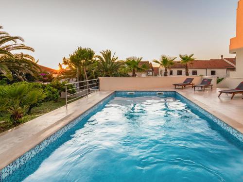 a swimming pool with blue water in front of a house at Apartment Villa 2 Pools-3 by Interhome in Sutivan