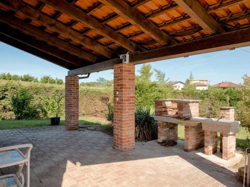 un patio de ladrillo con un banco y una mesa en Holiday Home San Giacomo by Interhome, en Tigliole