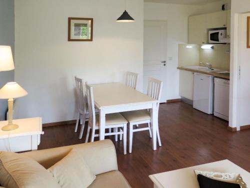 un salon avec une table et des chaises et une cuisine dans l'établissement Apartment Les Cottages du Lac T3 by Interhome, à Parentis-en-Born