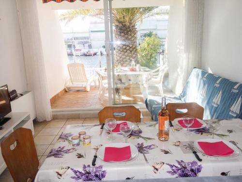 a dining room with a table with wine glasses at Apartment Le Nirvana-1 by Interhome in Le Grau-du-Roi