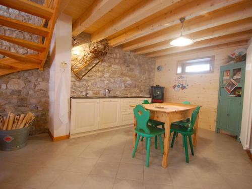 バルチスにあるApartment Albergo Diffuso - Cjasa Ustin-2 by Interhomeの木製のテーブルと緑の椅子のあるキッチン