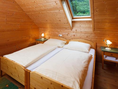 a bedroom with two beds in a log cabin at Holiday Home Sonnleiten-1 by Interhome in Schlierbach