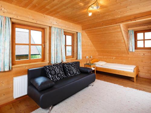 a living room with a black couch and a bed at Holiday Home Sonnleiten-1 by Interhome in Schlierbach