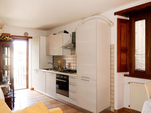 una cucina con armadietti bianchi e piano cottura di Apartment Ludovica by Interhome a Stazzona