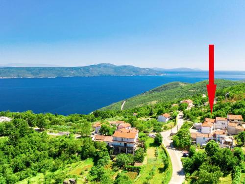 an aerial view of a house with a red arrow pointing to the water at Holiday Home Matea - MOD207 by Interhome in Martina