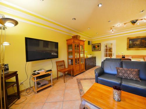 a living room with a couch and a flat screen tv at Holiday Home Dünenrose by Interhome in Groß Zicker