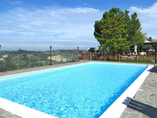 ein Pool mit blauem Wasser vor einem Zaun in der Unterkunft Apartment San Michele-1 by Interhome in Vinchio