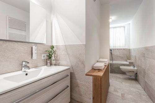 a white bathroom with a sink and a toilet at Villa Martiner Apartments Alex in Ortisei