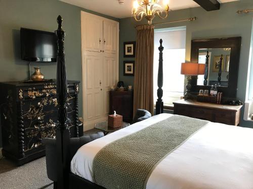 a bedroom with a bed and a television in it at The Bridge House in Bridport