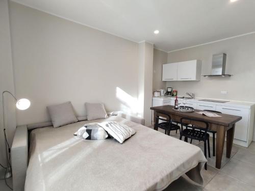 a bedroom with a bed and a table and a kitchen at Apartment Federico by Interhome in Olgiasca