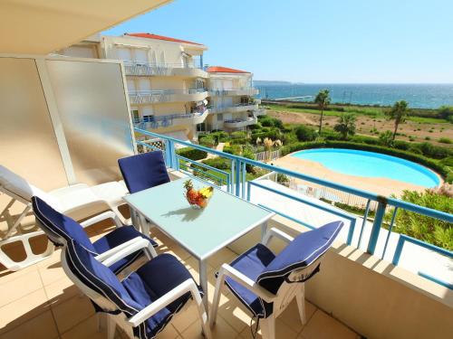 a balcony with a table and chairs and a swimming pool at Apartment Le Grand Large by Interhome in Juan-les-Pins