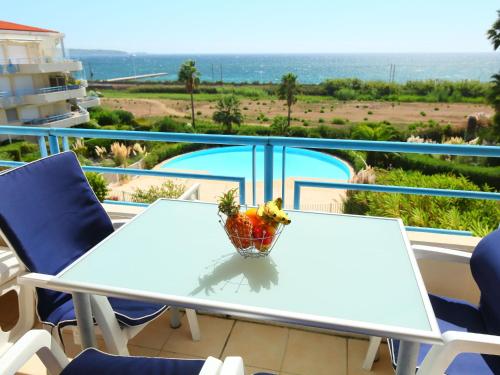 a table with a bowl of fruit on top of a balcony at Apartment Le Grand Large by Interhome in Juan-les-Pins