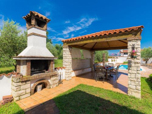 a patio with a fireplace and an outdoor oven at Holiday Home Ksenija-1 by Interhome in Čepljani