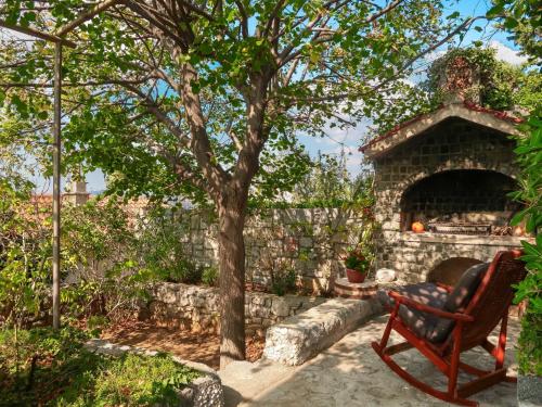 una panchina accanto a un muro di pietra con un albero di Apartment Donata by Interhome a Senj