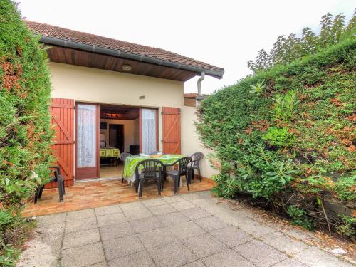 a house with a patio with a table and chairs at Holiday Home Sicard-5 by Interhome in Mimizan-Plage