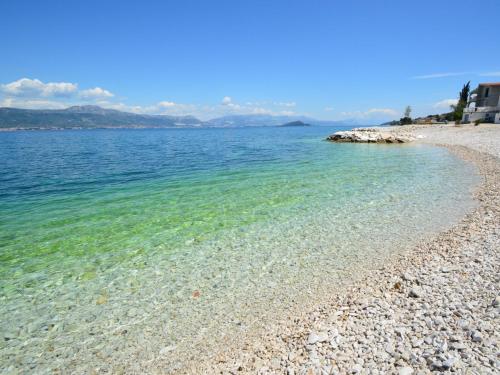 a beach with clear water and a rocky shore at Apartment Šarić-1 by Interhome in Trogir