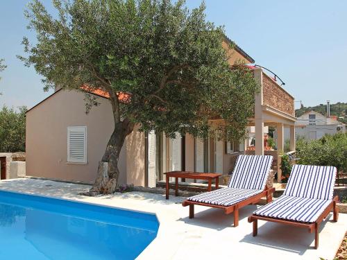 twee stoelen en een boom naast een zwembad bij Holiday Home Vinka by Interhome in Ražanj