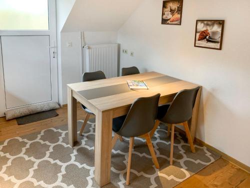 drewniany stół z 4 krzesłami w pokoju w obiekcie Holiday Home Vosshörn by Interhome w mieście Westerschoo