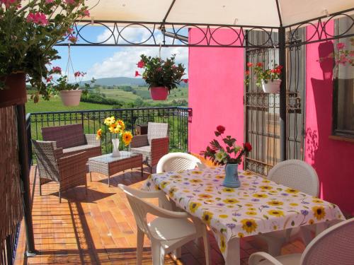 チェルタルドにあるHoliday Home Podere Conte Francesco-Alvino by Interhomeのピンクの壁のパティオ(テーブル、椅子付)