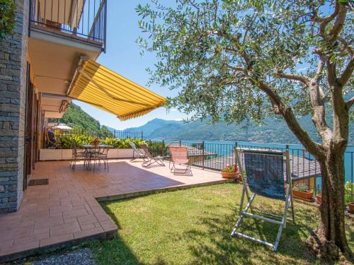 a patio with a table and chairs and a yellow umbrella at Apartment Paníco by Interhome in Dorio