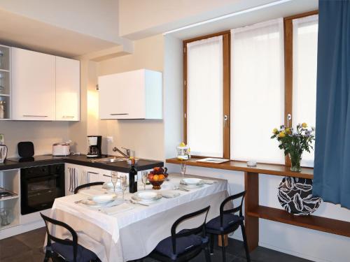 a kitchen with a table with a white table cloth at Apartment Bilocale by Interhome in Olgiasca