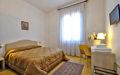 a hotel room with a bed and a window at Locanda Al Santuario in Peschiera del Garda