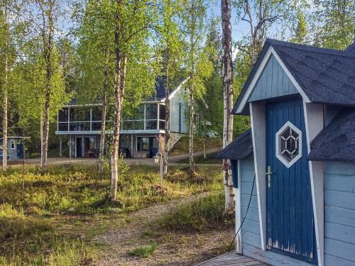 una casa con una puerta azul en el bosque en Holiday Home Äkäsjärven lomamökit 3 by Interhome, en Rauhala