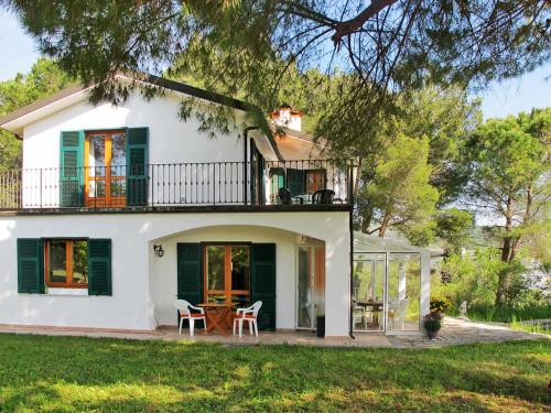a white house with a balcony and a table at Holiday Home Villa La Vigna - TAZ175 by Interhome in Torrazza