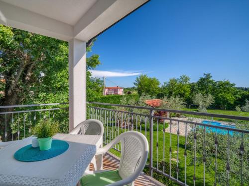 a balcony with a table and chairs and a view of a pool at Apartment Fiore-1 by Interhome in Gedići