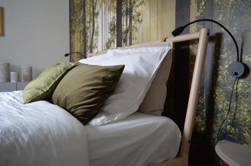 Una cama con dos almohadas encima. en Le Salix, petite maison proche de Lille, entre ville et campagne, en Wavrin