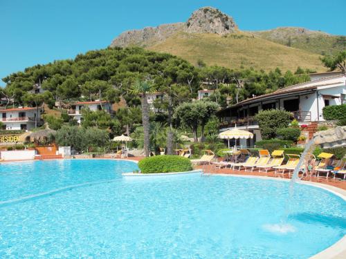 une grande piscine avec des chaises et une montagne dans l'établissement Apartment Costa di Kair ed Din-3 by Interhome, à Sperlonga